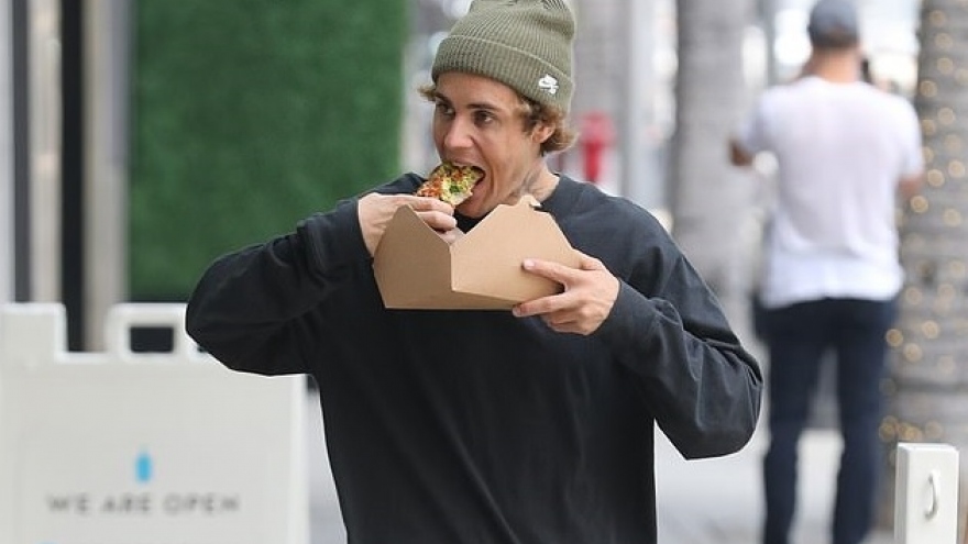 Justin Bieber thản nhiên ăn pizza khi đi dạo bộ trên phố ở Beverly Hills