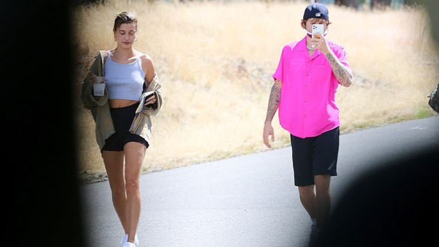 Justin Bieber mặc áo hồng rực, liên tục sử dụng điện thoại khi đi chơi cùng vợ