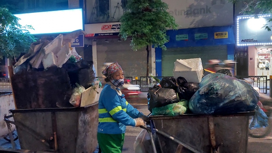 Nữ lao công miệt mài quét rác trong đêm lạnh đầu đông