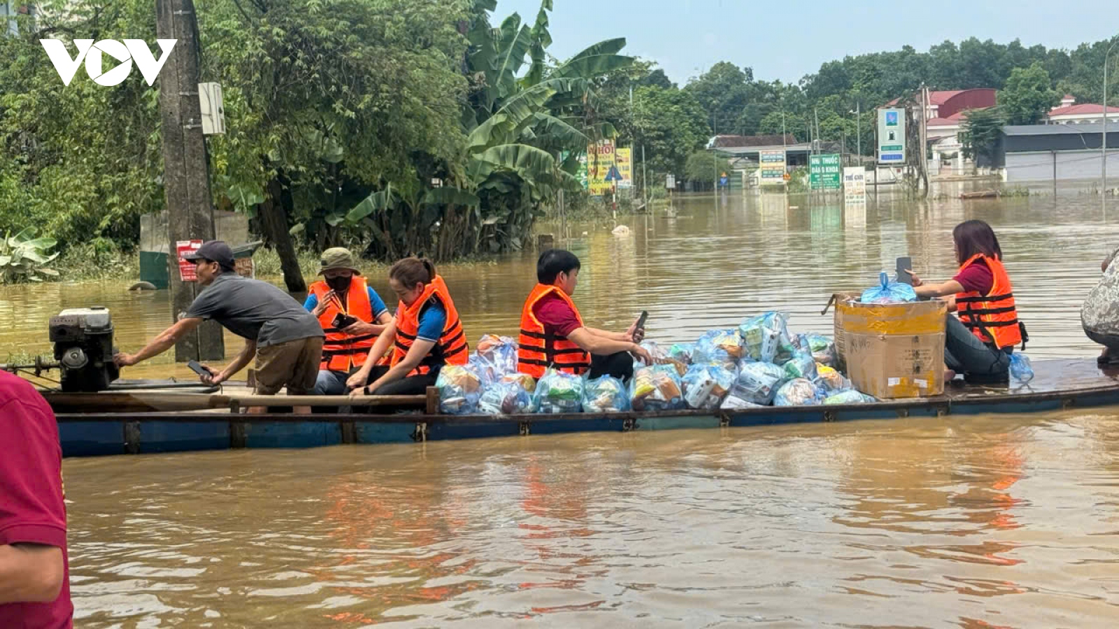 Người dân phấn khởi bơi từ vùng nước cô lập ra nhận hàng cứu trợ