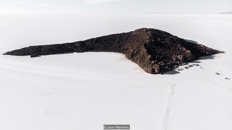 Nằm rải rác khắp cánh đồng muối là những ngọn núi lửa còn sót lại, chúng tạo thành các chấm đen nổi bật giữa khung cảnh trắng xóa. Đến đây, du khách cũng bắt gặp những dấu tích của san hô và vỏ ốc xung quanh, bởi cách đây khoảng 40.000 năm, toàn bộ khu vực này là một hồ nước mặn khổng lồ. Ảnh: Juan Martinez.