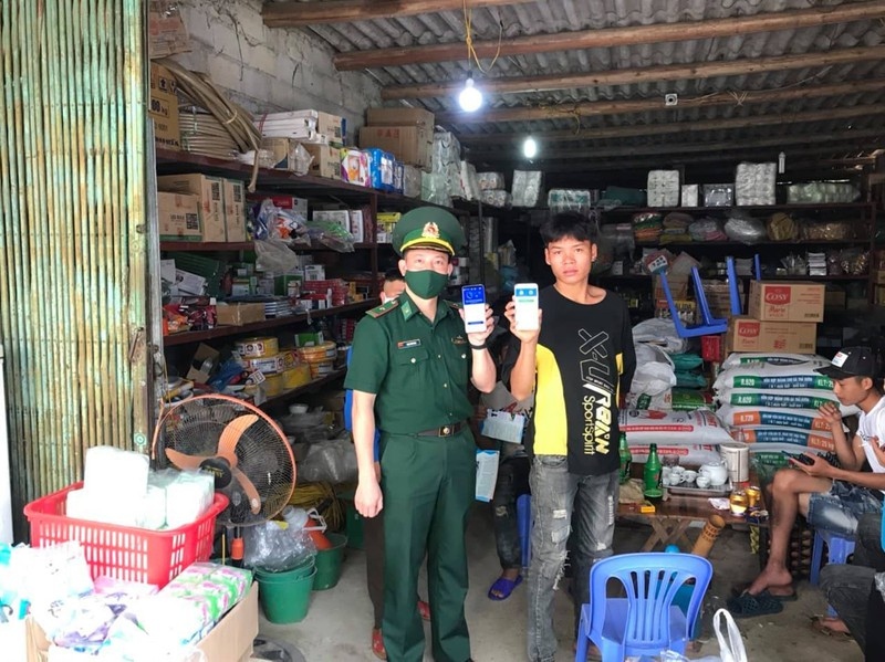 Bộ đội biên phòng hướng dẫn người dân cài đặt ứng dụng cảnh báo truy vết người nhiễm Covid-19 qua điện thoại.