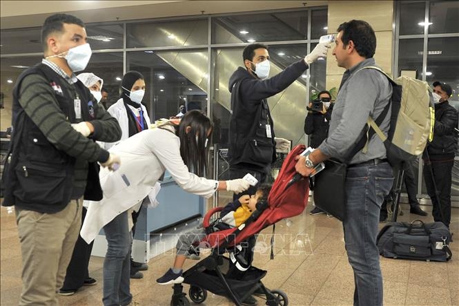 Kiểm tra thân nhiệt nhằm ngăn chặn sự lây lan của COVID-19 tại sân bay quốc tế Cairo, Ai Cập. Ảnh: AFP/TTXVN
