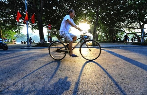 A man cycles on a street near Hoan Kiem Lake - a popular tourist destination in Hanoi (Photo: VNA)