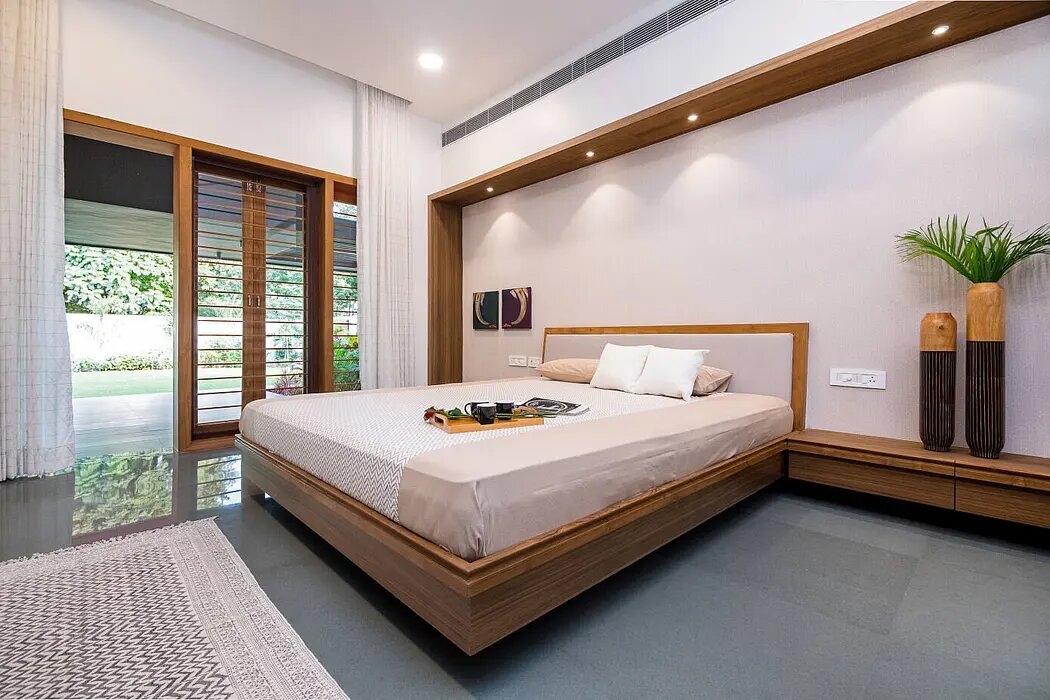 Trong một phòng ngủ khác, giường gắn với kệ gỗ tạo sự nối tiếp liền mạch.