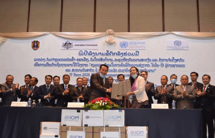 Tại lễ ký kết triển khai dự án, đại diện Tổ chức di cư quốc tế (IOM) trao tặng Lào một số vật tư y tế phòng chống dịch Covid-19. Ảnh: KT