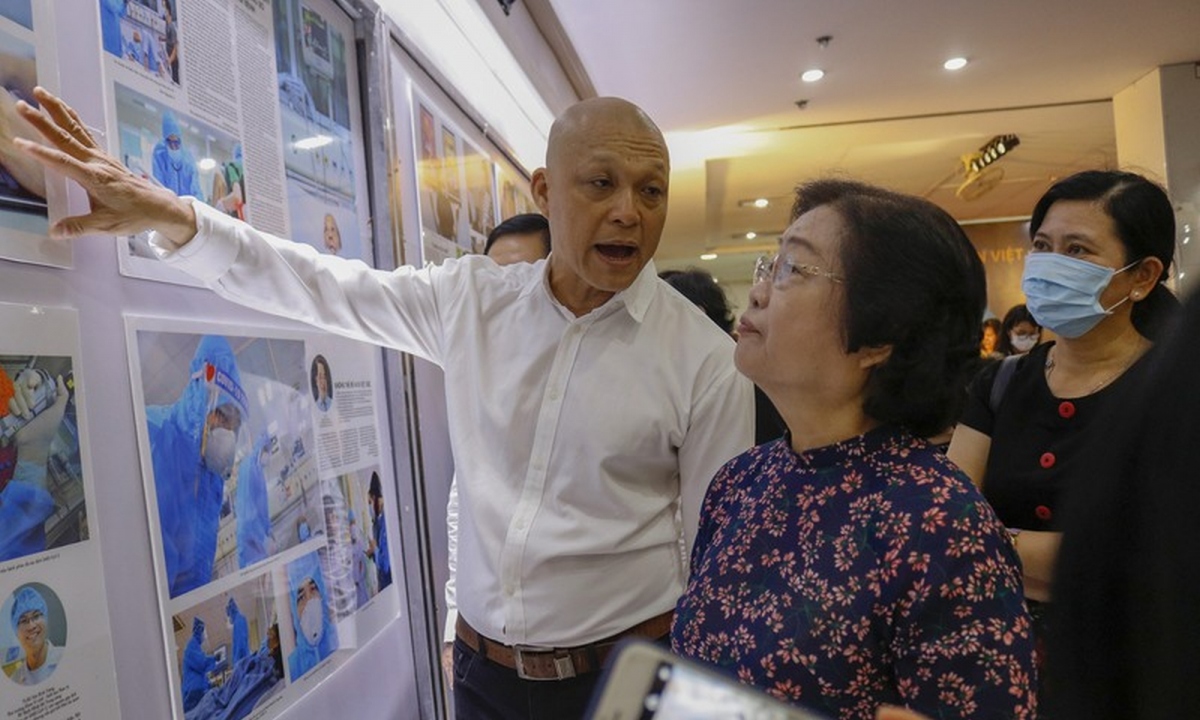 Nghệ sĩ nhiếp ảnh Nguyễn Á giới thiệu những bức ảnh có chủ đề phòng chống Covid-19 với nguyên Phó chủ tịch nước Trương Mỹ Hoa. Ảnh: Pháp luật TPHCM