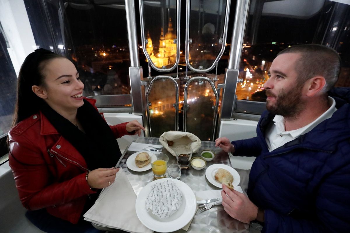 Hai vị khách Hajnalka Lutor và Janos Katus thưởng thức bữa tối trong ca bin đu quay. 