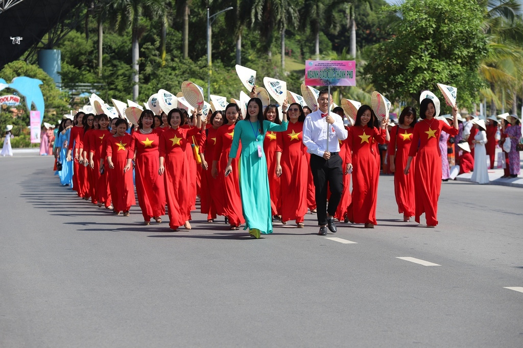 Teachers wear Ao Dai featuring national flags as they attend the street parade in Ha Long city in response to the celebratory week.