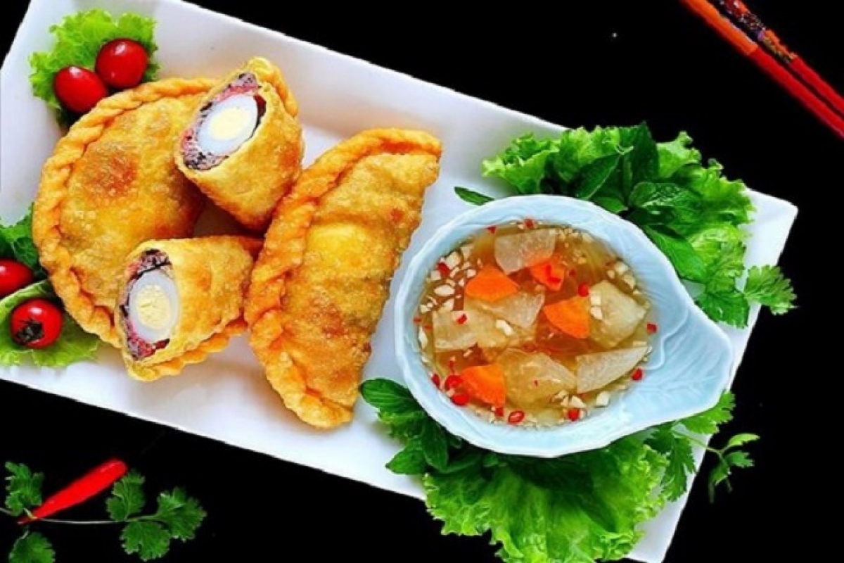 Banh goi, pillow cake, is not baked but deep fried in vegetable oil in order to create a charming yellow pastry skin. Its texture is crispy and smells fragrant. The most important part is making dipping sauce with the exact proportion of garlic, chili, sugar, lime juice, fish sauce, and water.