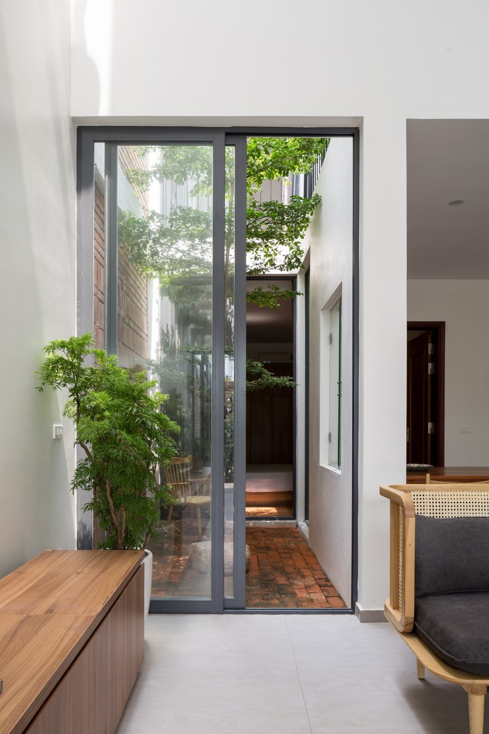 Thiết kế cửa kính cao giúp ngôi nhà có cảm giác cao ráo, thông thoáng, đồng thời giúp hơi thở, cuộc sống thiên nhiên len lỏi được vào không gian bên trong nhà.