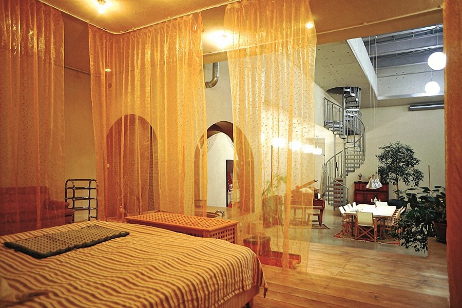 Ranh giới phòng ngủ được ngăn bằng những tấm rèm thưa. Từ phòng ngủ có thể quan sát được cả không gian rộng lớn bên ngoài.