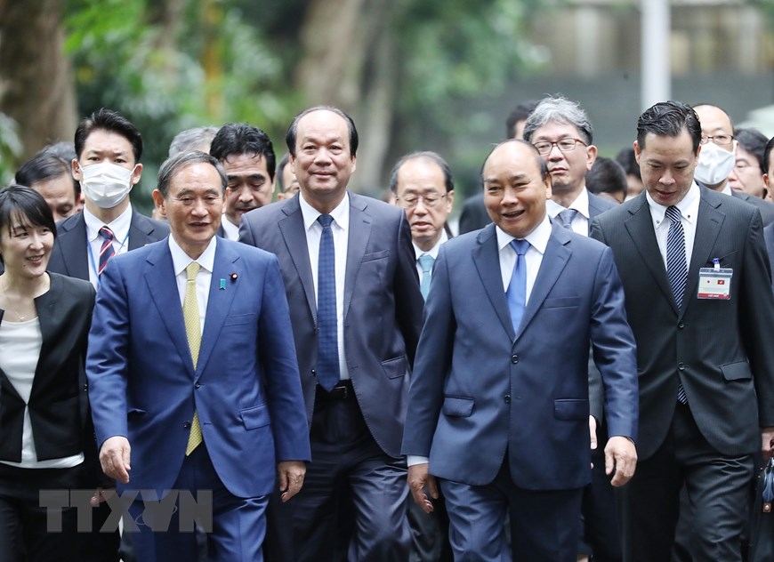 Thủ tướng Nguyễn Xuân Phúc và Thủ tướng Nhật Bản Suga Yoshihide đi dạo đường Xoài trong Khu Di tích Chủ tịch Hồ Chí Minh tại Phủ Chủ tịch. (Ảnh: Lâm Khánh/TTXVN)