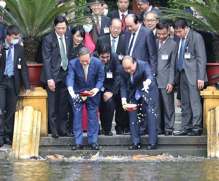 Thủ tướng Nguyễn Xuân Phúc và Thủ tướng Nhật Bản Suga Yoshihide bên Ao cá Bác Hồ trong Khu Di tích Chủ tịch Hồ Chí Minh tại Phủ Chủ tịch. (Ảnh: Lâm Khánh/TTXVN)