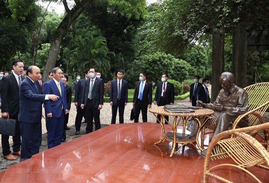 Thủ tướng Nguyễn Xuân Phúc và Thủ tướng Nhật Bản Suga Yoshihide tham quan nơi Bác Hồ đọc sách trong Khu Di tích Chủ tịch Hồ Chí Minh. (Ảnh: Thống Nhất/TTXVN)