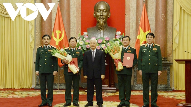 Tổng Bí thư, Chủ tịch nước Nguyễn Phú Trọng trạo Quyết định và tặng hoa cho hai tướng quân đội được thăng quân hàm.