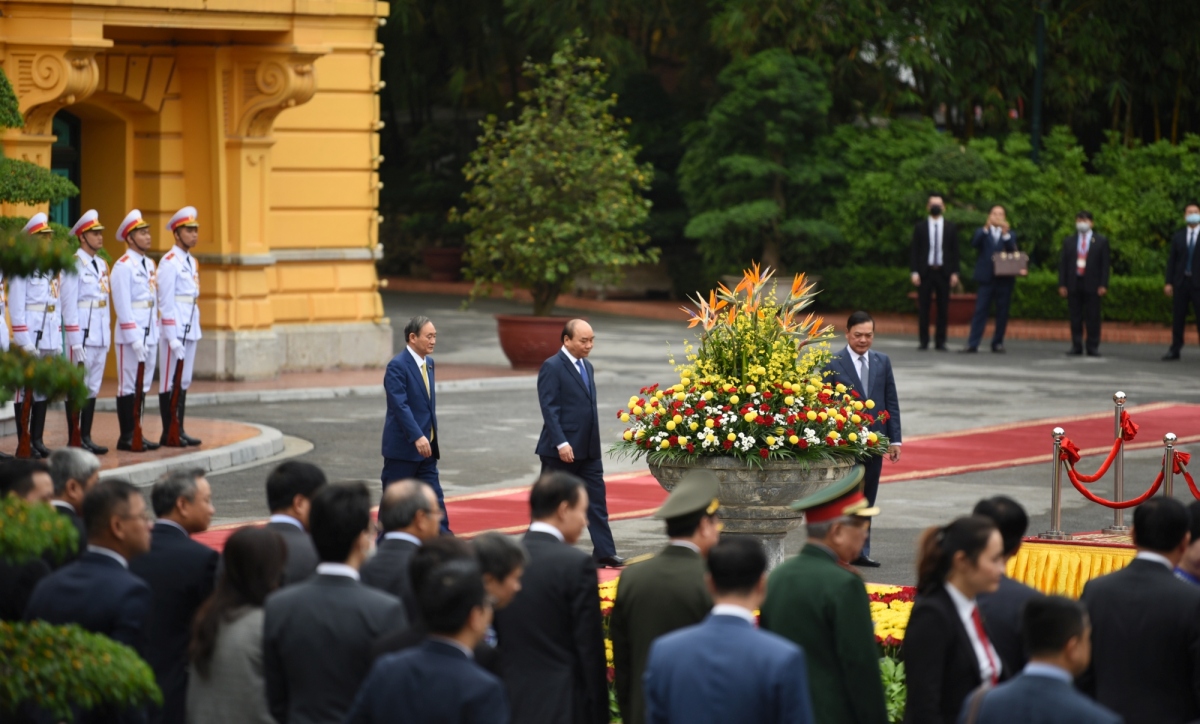 Trong tiếng nhạc chào mừng, Thủ tướng Nguyễn Xuân Phúc mời Thủ tướng Nhật Bản Suga Yoshihide bước lên bục danh dự.