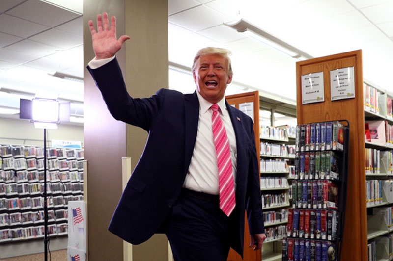 Ông Trump vẫy tay với mọi người sau khi bỏ phiếu xong - Ảnh: Reuters