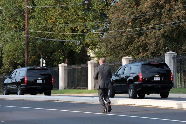 Đặc vụ chạy theo bên ngoài xe bọc thép chở ông Trump rời bệnh viện Walter Reed ở ngoại ô thủ đô Washington, nơi ông được điều trị Covid-19. Ảnh: Reuters