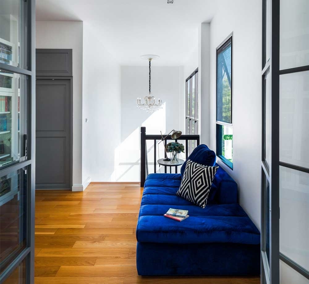 Chiếc ghế màu xanh đậm bên cạnh cửa sổ là điểm nhấn vô cùng sáng tạo cho một góc thư giãn tuyệt vời.