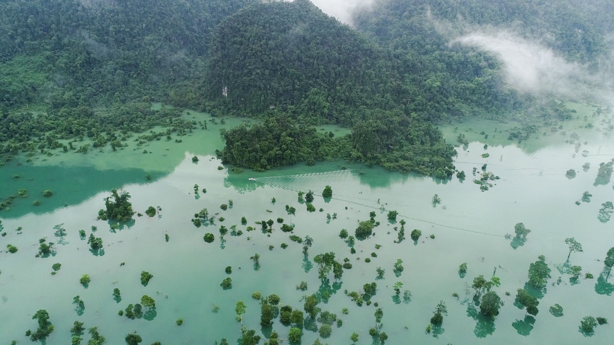 The clear, turquoise-green floodwaters form a large lake engulfing old trees for about a month.