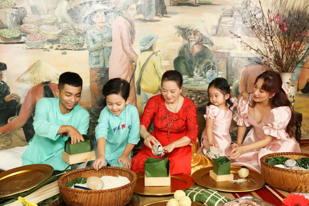 Vợ chồng Khánh Thi dạy hai con gói bánh chưng trong MV ngày Xuân