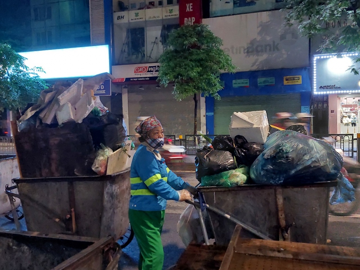 Nữ lao công miệt mài quét rác trong đêm lạnh đầu đông