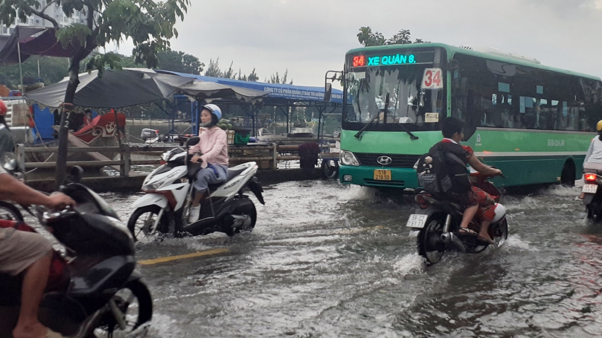 Triều cường dâng cao, người dân ở TP.HCM lội nước về nhà sau giờ tan tầm