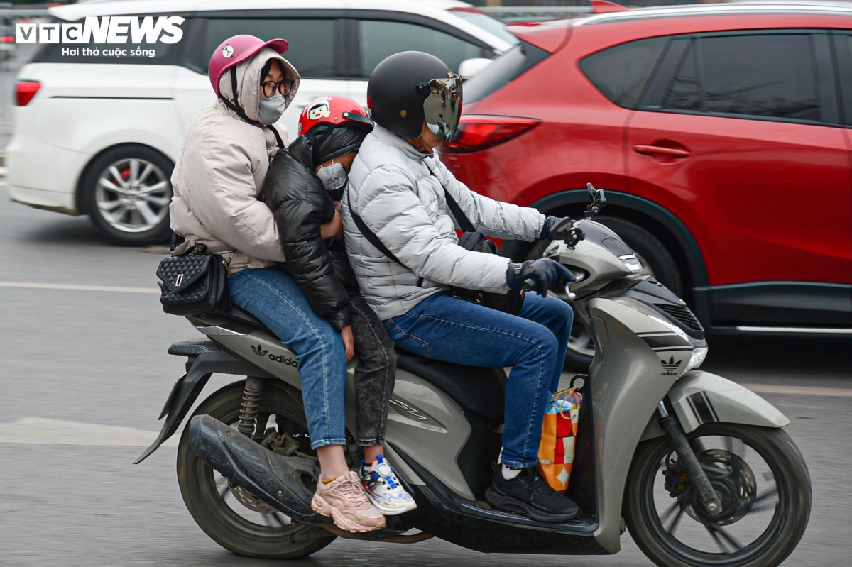 Trẻ nhỏ trùm kín mít, ngủ gục trên xe máy theo cha mẹ rời Thủ đô về quê đón Tết