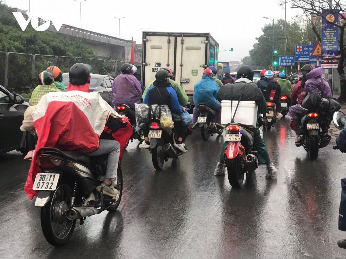 Người dân đi xe máy "đội" mưa rét trở lại Thủ đô ngày cuối nghỉ Tết