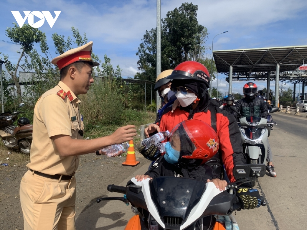 Cảnh sát giao thông Đắk Nông phát nước uống, bánh mì cho người dân trở lại sau Tết