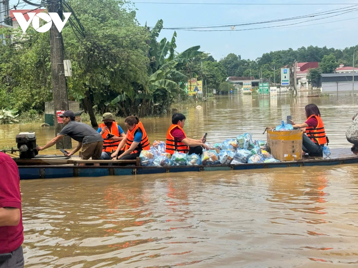 Người dân phấn khởi bơi từ vùng nước cô lập ra nhận hàng cứu trợ